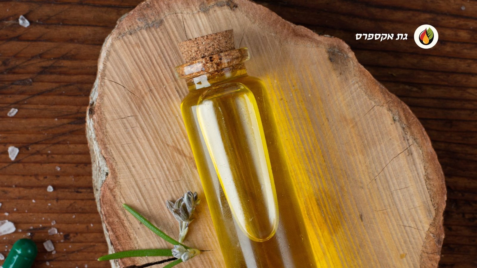 בקבוקון זכוכית שבתוכו מיצוי גת, הבקבוקון מונח על בוצ'ר חיתוך של בשרים מעץ. בצד שמאל למעלה לוגו אתר "גת אקספרס"