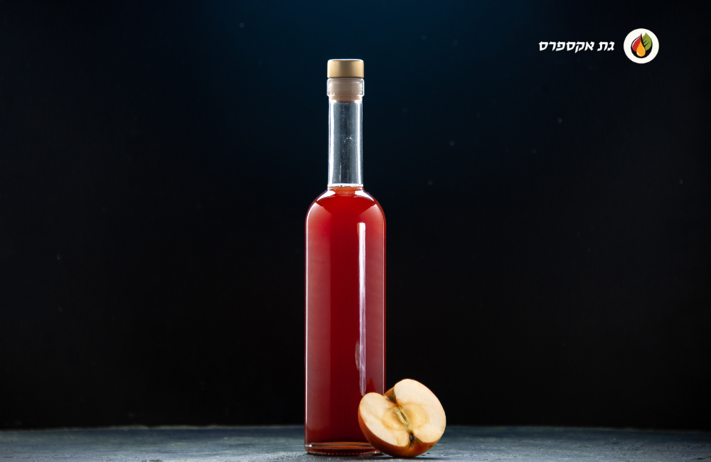 רקע התמונה שחור וניתן לראות בקבוק מיץ גת אדום. בצד ימין למעלה לוגו אתר גת אקספרס ועל הבקבוק למטה מונח חצי תפוח.